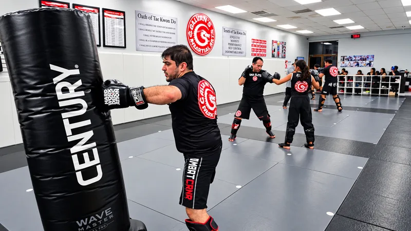 Students working combinations on a heavy bag and in pairs with gloves and shin guards during an MMA class at Galvan’s Martial Arts in Brownsville