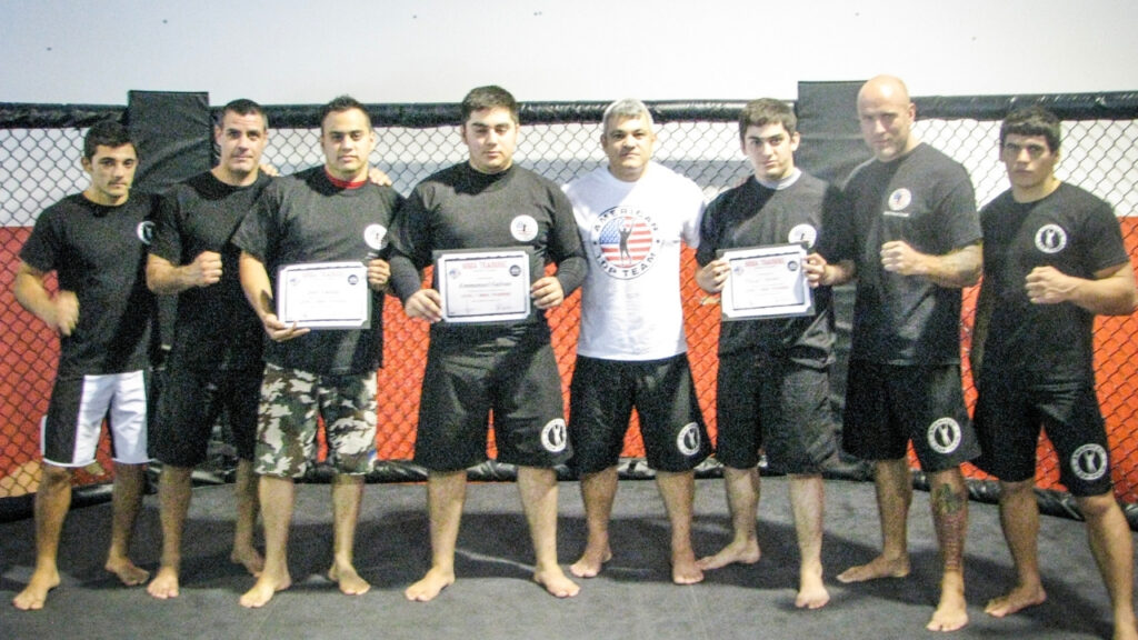 Martial artists holding training certificates at American Top Team
