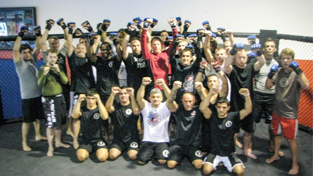 Large group of martial artists celebrating after training at American Top Team
