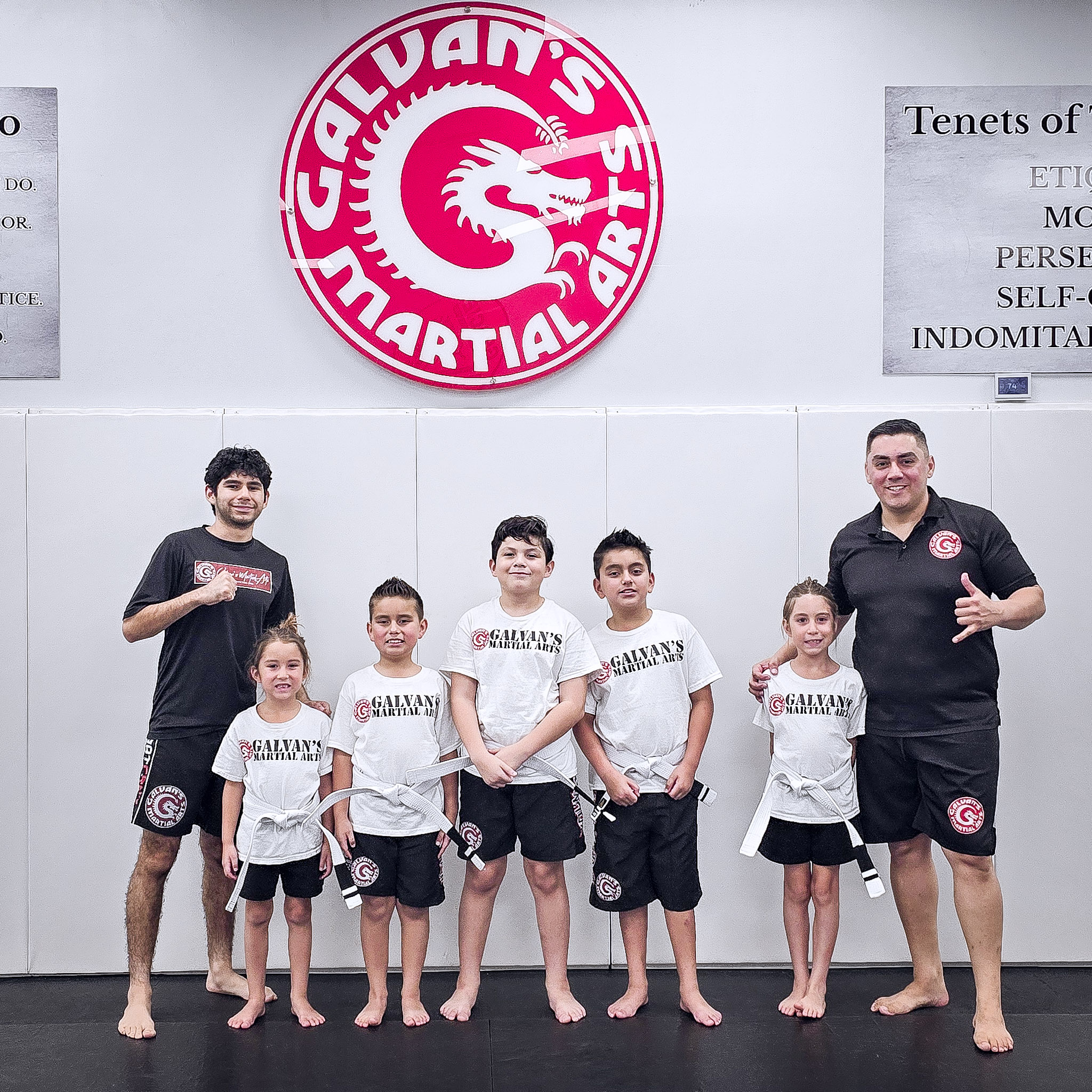 Kids MMA students with white belts standing with their instructors at Galvan's Martial Arts in Brownsville, TX